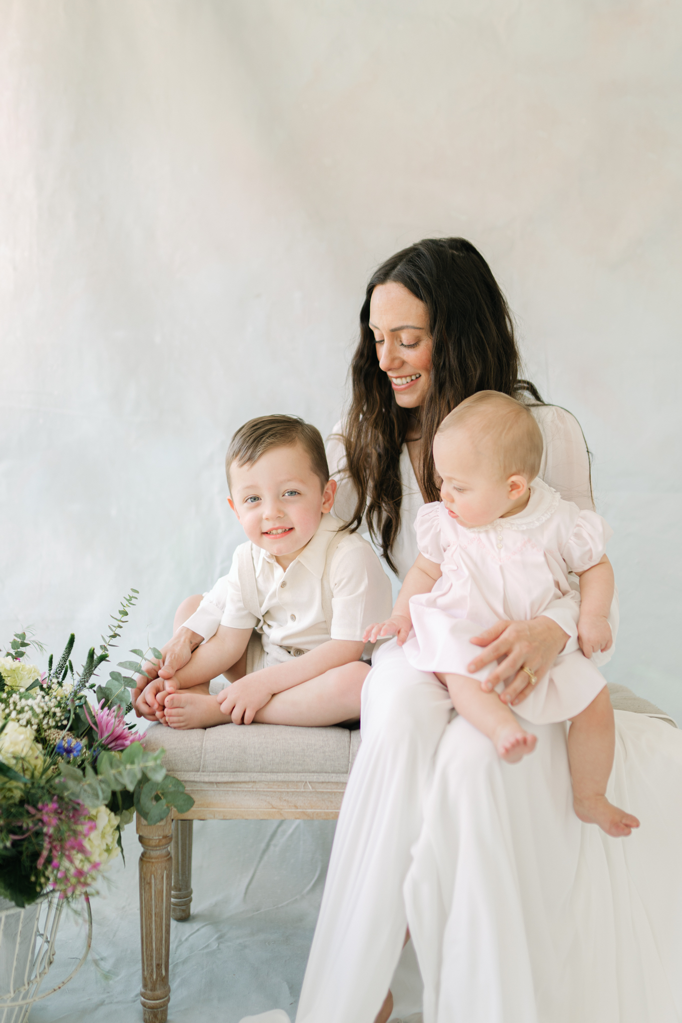 Mother holding children in lap in franklin, tn newborn photography studio